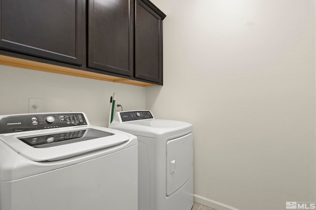 laundry area with washer and dryer, baseboards, and cabinet space