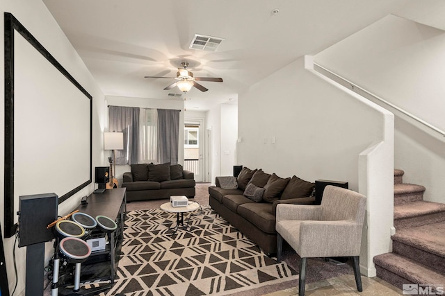 living room with stairway, visible vents, carpet floors, and ceiling fan