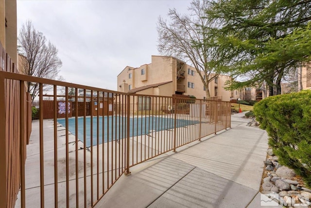 community pool featuring a patio and fence