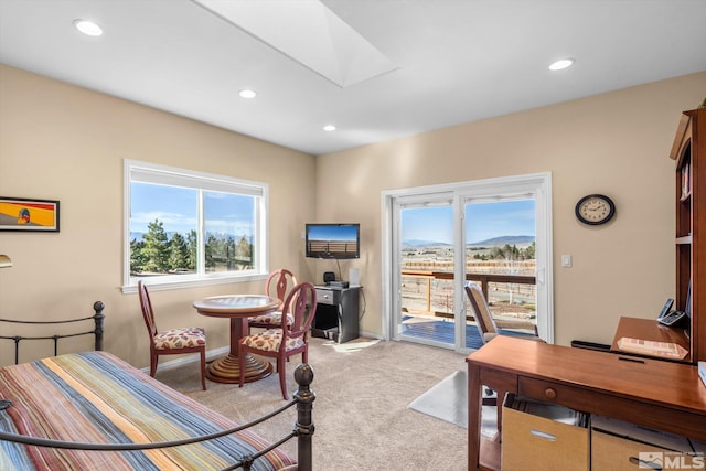 bedroom with multiple windows, light colored carpet, a skylight, and access to outside