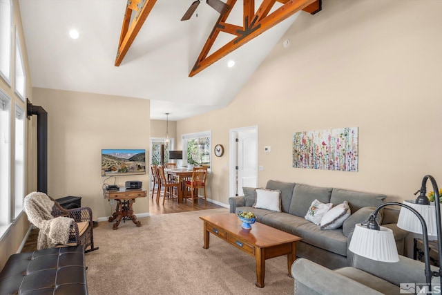 living area with baseboards, carpet floors, high vaulted ceiling, ceiling fan, and beamed ceiling