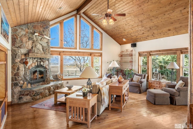 living area featuring high vaulted ceiling, a stone fireplace, hardwood / wood-style floors, and wooden ceiling