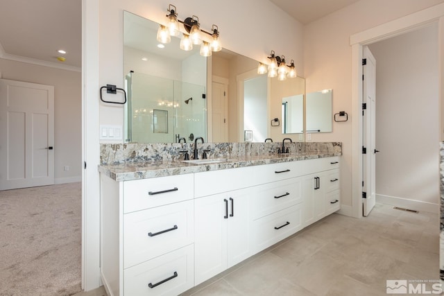 bathroom featuring baseboards, a stall shower, and a sink