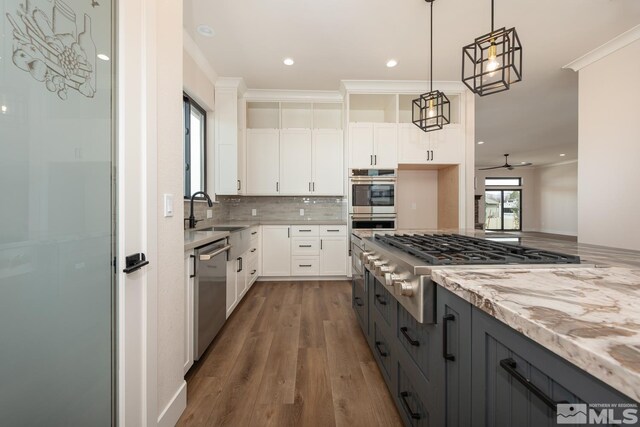 kitchen with light stone countertops, gray cabinetry, ornamental molding, a sink, and appliances with stainless steel finishes