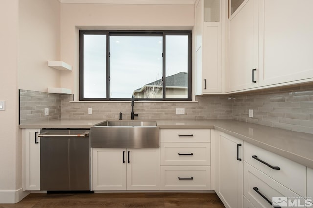 kitchen with white cabinets, dishwasher, light countertops, and a sink