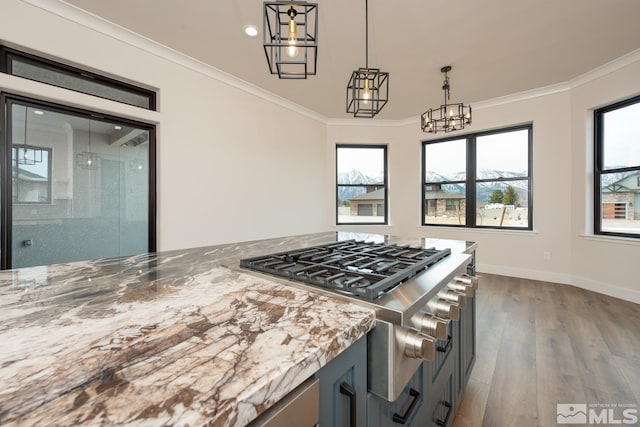 kitchen with light stone counters, dark wood-style floors, baseboards, crown molding, and decorative light fixtures