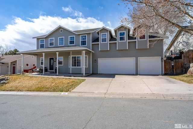 view of front of property with a porch, fence, concrete driveway, a front yard, and a garage