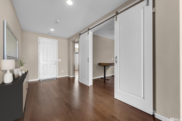 interior space featuring baseboards, visible vents, dark wood finished floors, recessed lighting, and a barn door