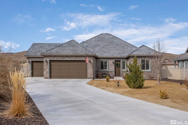 view of front of home featuring stucco siding, driveway, an attached garage, and fence