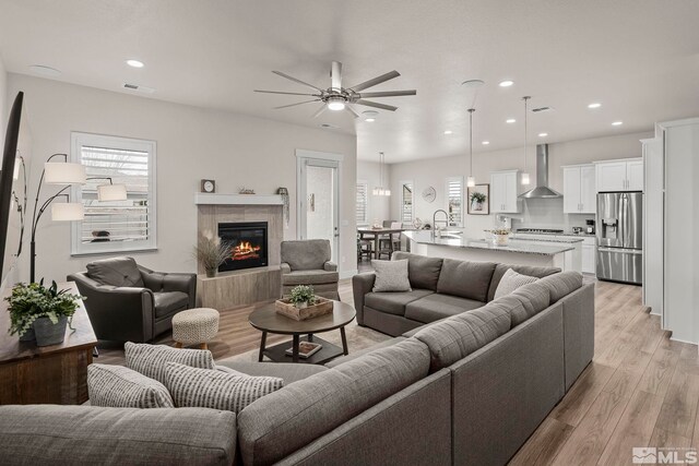 living area featuring visible vents, light wood-style flooring, recessed lighting, a fireplace, and ceiling fan