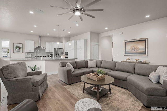 living area with recessed lighting, light wood-type flooring, and ceiling fan