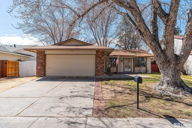 view of front of home featuring brick siding, concrete driveway, a garage, and fence