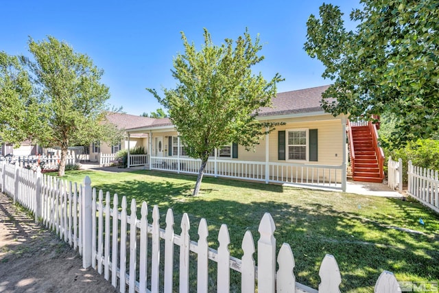 view of front of home with a fenced front yard, stairway, a porch, and a front lawn