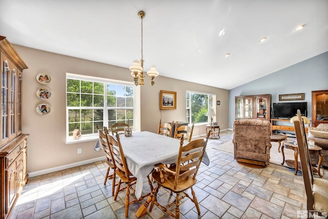 dining room featuring an inviting chandelier, stone tile floors, a healthy amount of sunlight, and baseboards