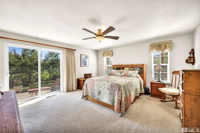 bedroom with visible vents, light colored carpet, a ceiling fan, and access to outside