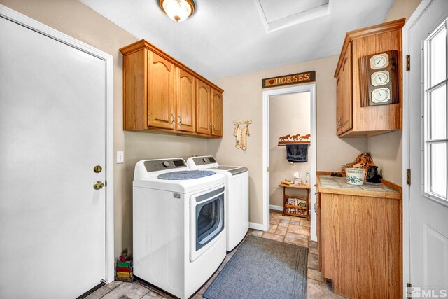 clothes washing area featuring cabinet space, baseboards, a wealth of natural light, and washer and clothes dryer