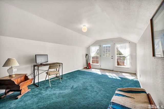 interior space with baseboards, carpet, lofted ceiling, a textured wall, and a textured ceiling