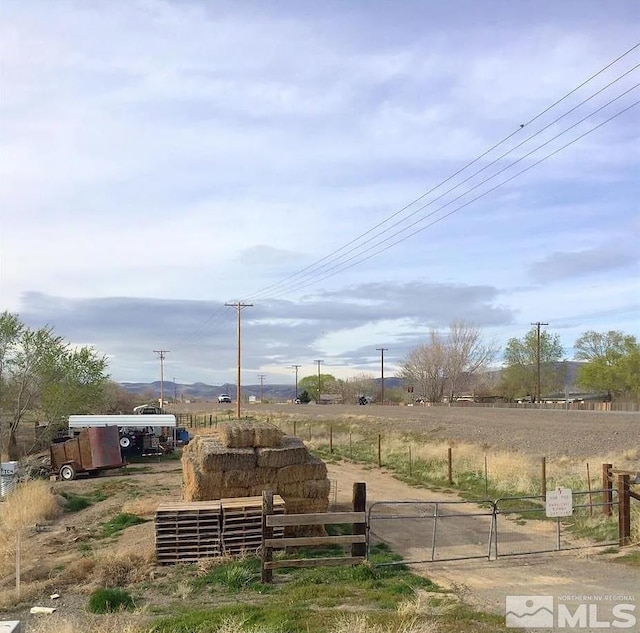 view of yard featuring a rural view and fence