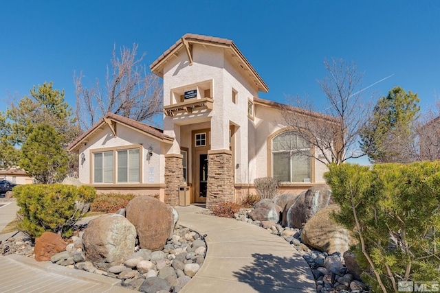 mediterranean / spanish home with a tiled roof and stucco siding