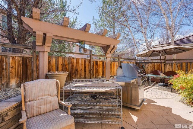 view of patio / terrace featuring exterior kitchen, area for grilling, and fence