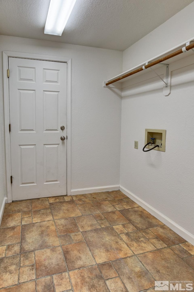 laundry area featuring laundry area, hookup for a washing machine, baseboards, and a textured ceiling