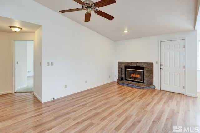 unfurnished living room with a stone fireplace, baseboards, light wood-style floors, and a ceiling fan