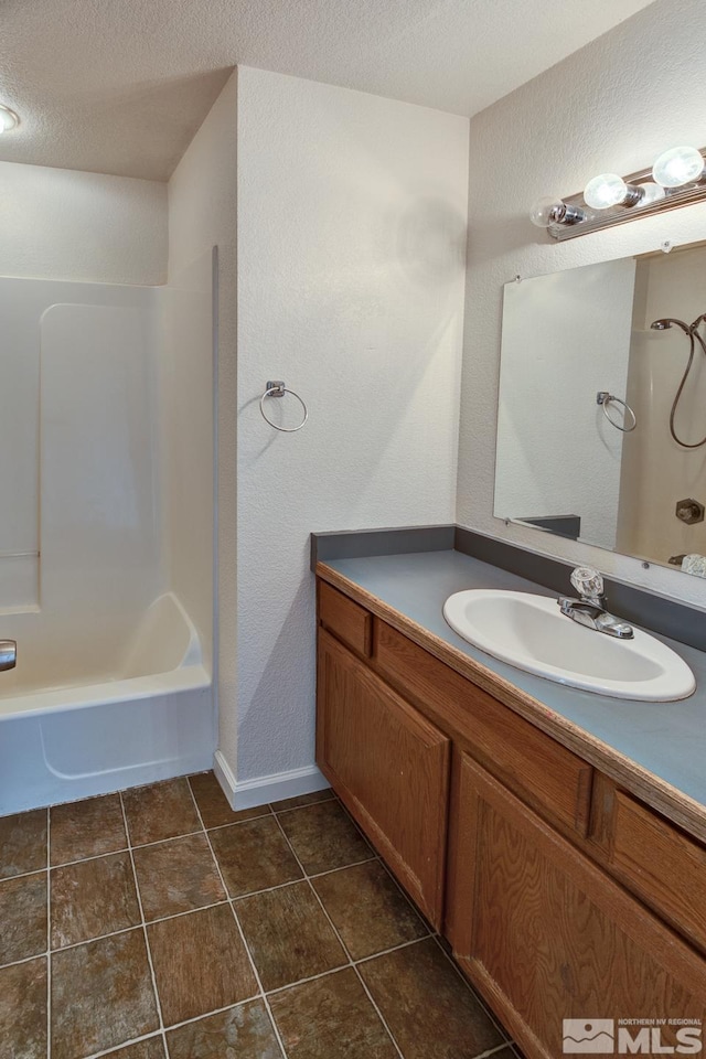 full bath with tile patterned floors, shower / bath combination, a textured ceiling, and vanity