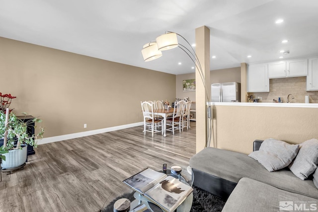 living room with recessed lighting, baseboards, and wood finished floors