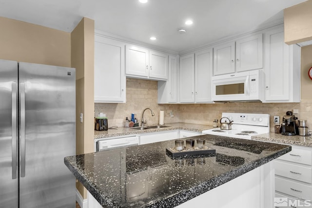 kitchen with white appliances, white cabinets, backsplash, and a sink