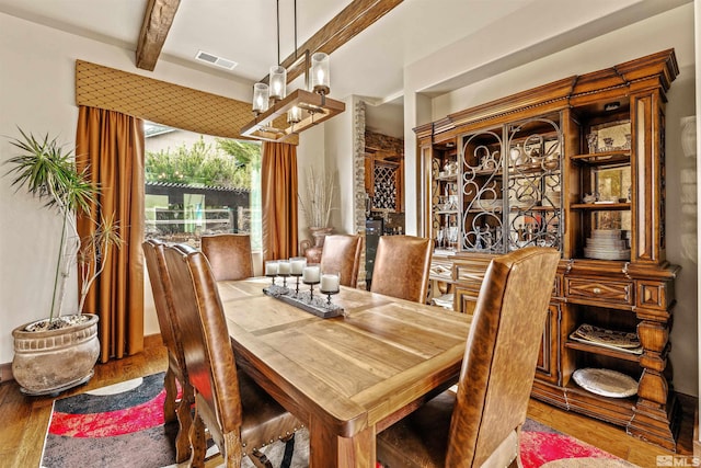 dining room with visible vents, beam ceiling, wood finished floors, and a chandelier