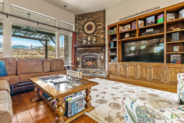 living area with visible vents, a fireplace, and hardwood / wood-style flooring