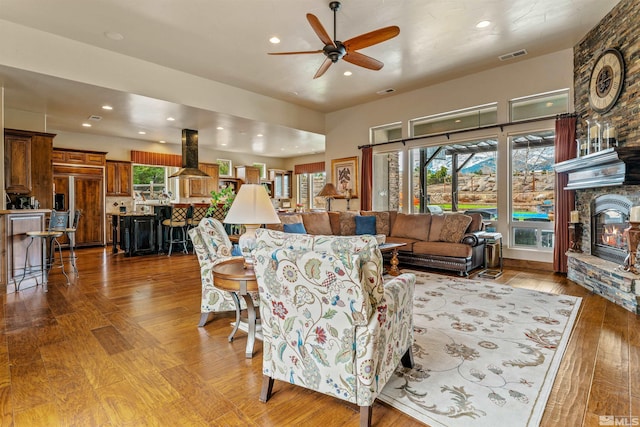 living area with visible vents, recessed lighting, a fireplace, ceiling fan, and wood-type flooring