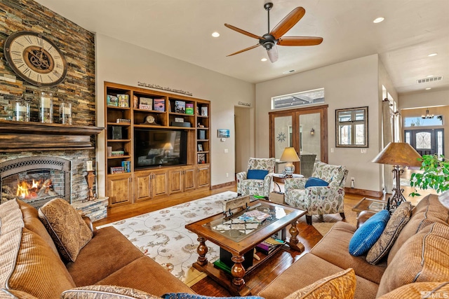 living area featuring a fireplace, recessed lighting, wood finished floors, and visible vents