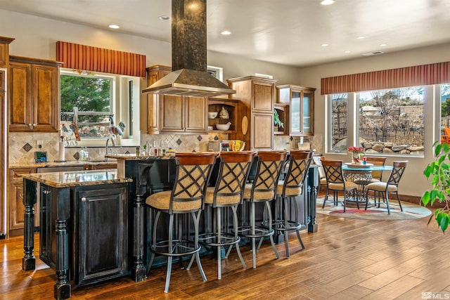 kitchen featuring dark wood-style floors, a kitchen island, tasteful backsplash, and open shelves