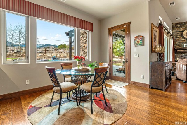 dining room featuring hardwood / wood-style flooring, visible vents, and baseboards