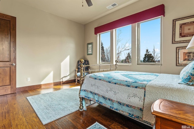 bedroom featuring visible vents, a ceiling fan, baseboards, and hardwood / wood-style flooring