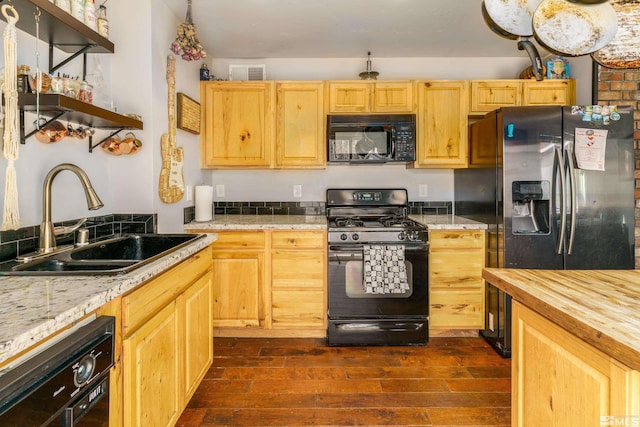 kitchen with visible vents, black appliances, light brown cabinets, a sink, and wood counters