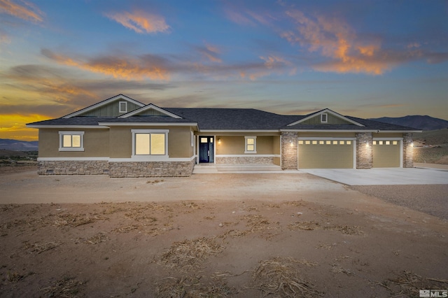 view of front of home with stucco siding, an attached garage, concrete driveway, and roof with shingles