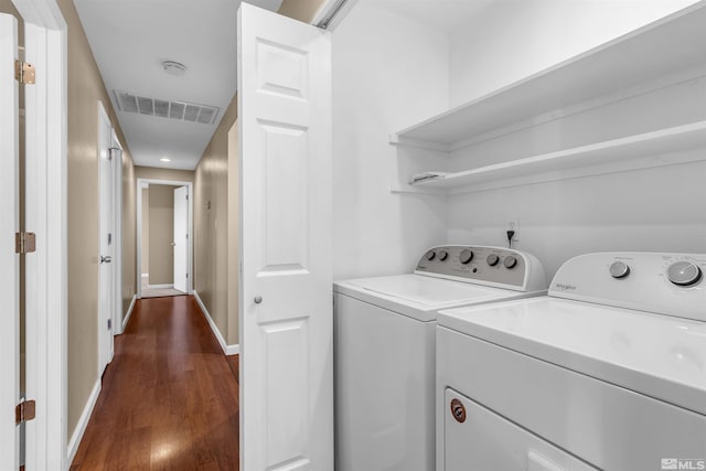 washroom with visible vents, baseboards, dark wood finished floors, laundry area, and independent washer and dryer