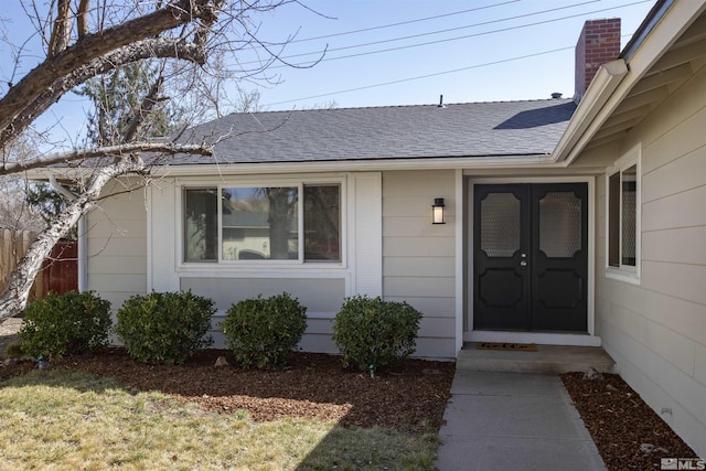 property entrance with roof with shingles