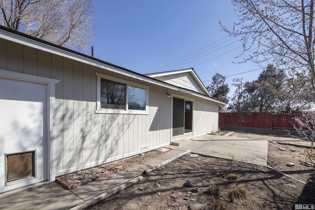 view of home's exterior with a patio area and fence