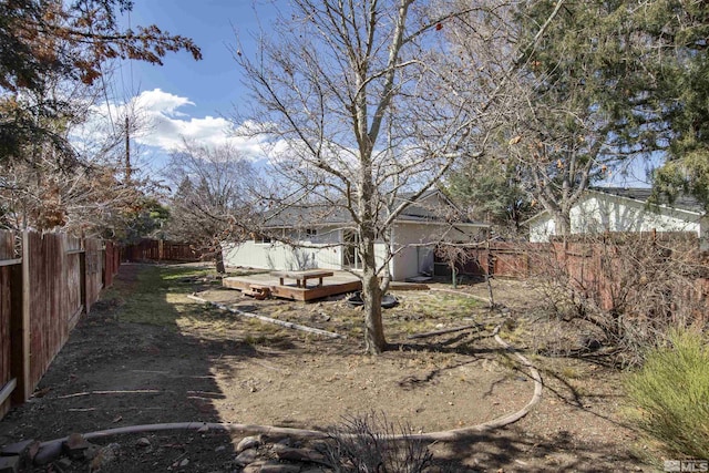 view of yard with a wooden deck and a fenced backyard