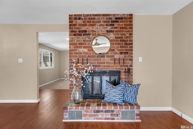 interior details featuring wood finished floors, a fireplace, and baseboards