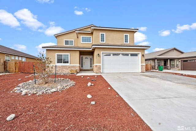 traditional-style house featuring stucco siding, stone siding, driveway, and fence