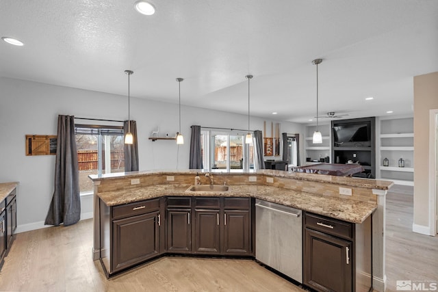 kitchen with a sink, light wood-type flooring, and stainless steel dishwasher