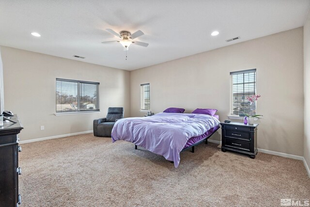 bedroom with multiple windows, visible vents, and light carpet