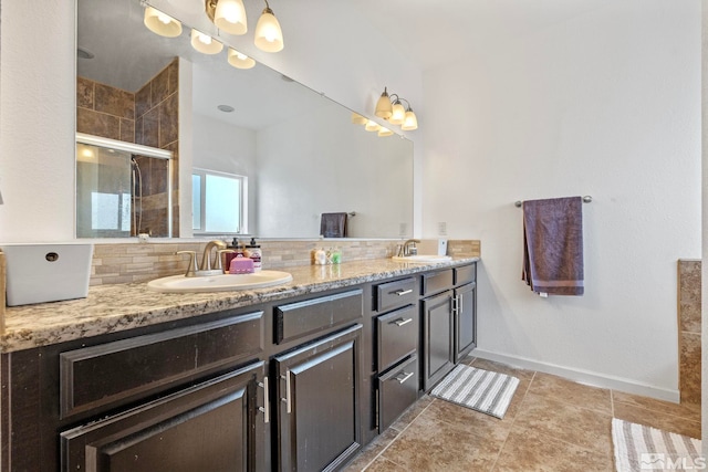 bathroom featuring a shower stall, double vanity, tasteful backsplash, and a sink