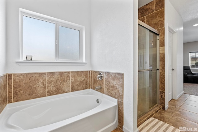 full bathroom featuring tile patterned floors, a garden tub, and a stall shower