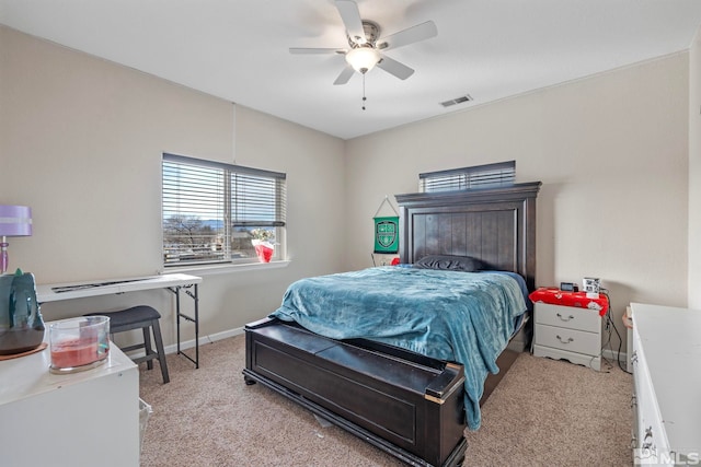 bedroom with ceiling fan, light colored carpet, visible vents, and baseboards