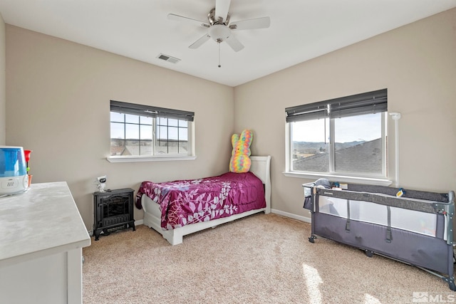 bedroom featuring visible vents, multiple windows, baseboards, and ceiling fan